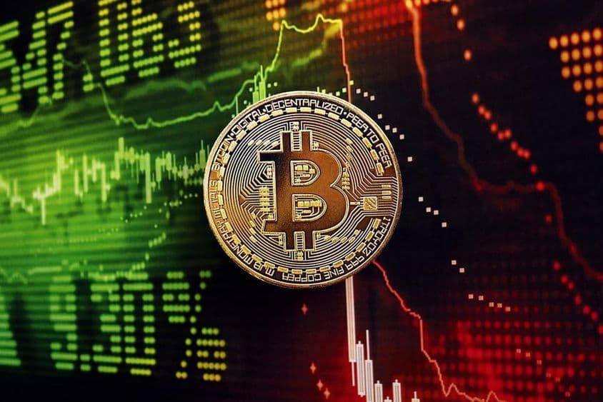 Bitcoin coin with a stock market chart in the background.