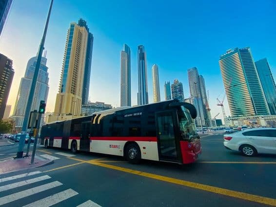 Dubai bus with skyscrapers in the background.