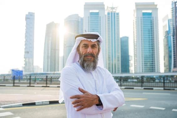 Elderly Dubai man with skyscrapers in the background.