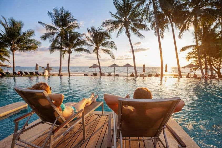 Maldives, young couple sunbathing at sunset.