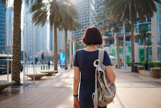 Woman walking in Dubai with a backpack.