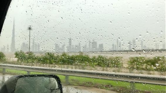 Raindrops rolling down a car window.