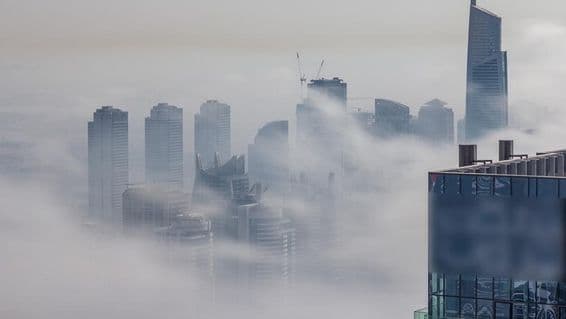 Dubai skyscrapers enveloped in fog.