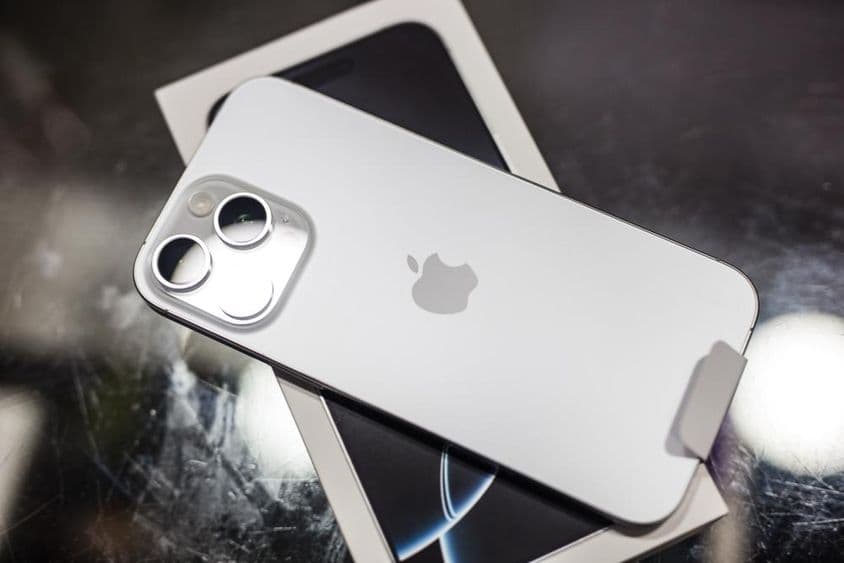 iPhone resting on its box on a table.