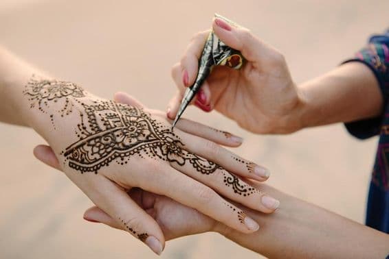Henna being applied to a woman's hand.