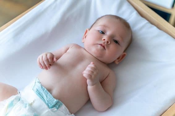 White baby lying in a diaper.