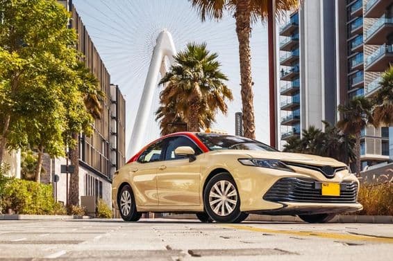 Dubai taxi with a ferris wheel in the background.