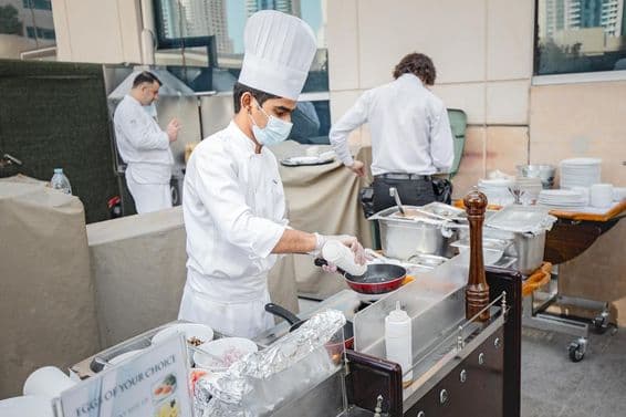 Chef frying an egg in a kitchen.
