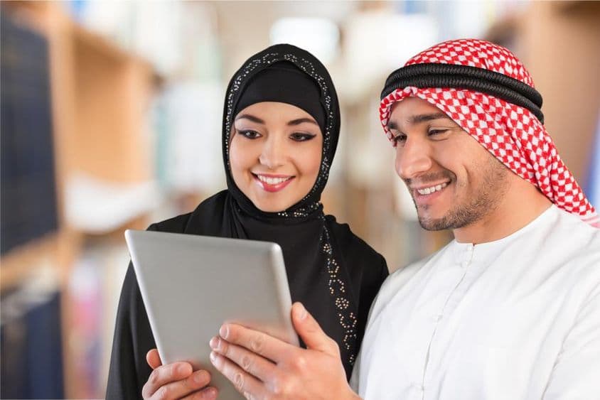 Arabic students looking at study material on a tablet.