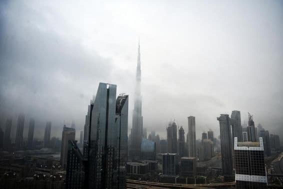 Dubai skyline with buildings shrouded in clouds.