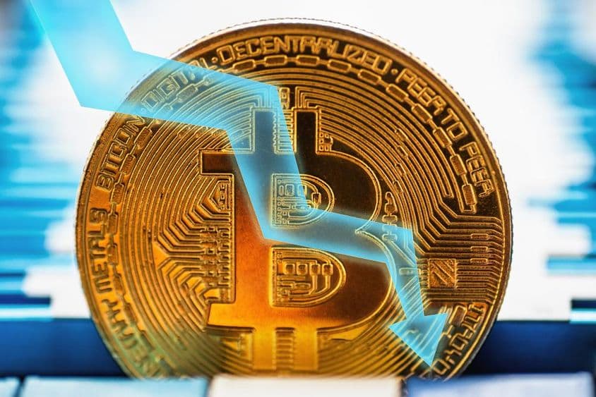 Golden Bitcoin coin - cryptocurrency symbol and arrow pointing down on technical background.