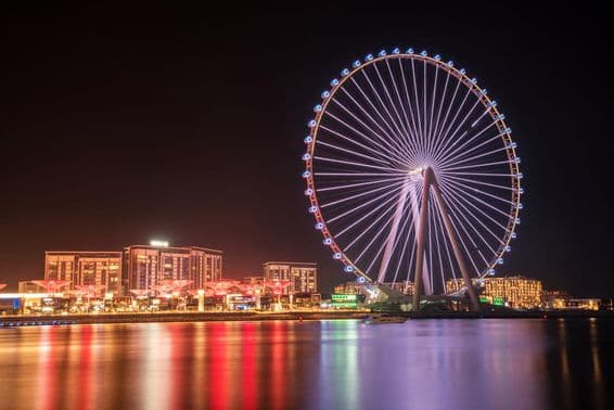 Ain Dubai Ferris wheel with buildings in the background.