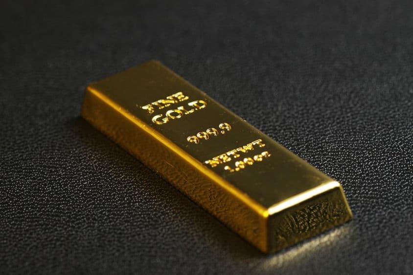 999.9 purity gold bar on black background.