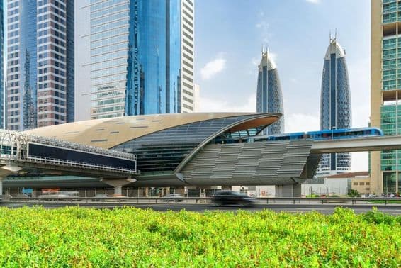 A Dubai metro arriving at the Financial Centre station in downtown Dubai, UAE, with stunning skyscrapers in the background.