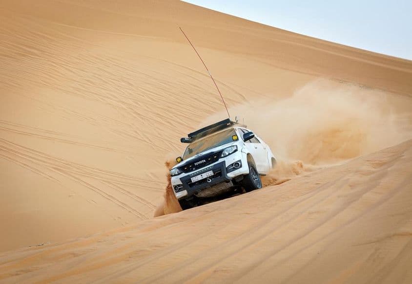 4x4 vehicle racing on a dune.