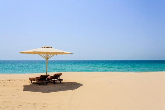 Sun loungers on the sandy Jumeirah Beach, Dubai.