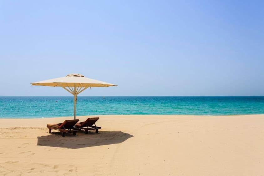 Sun loungers on the sandy Jumeirah Beach, Dubai.