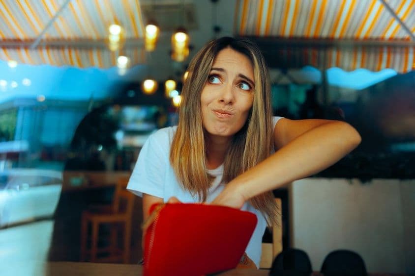 Worried female guest without enough money due to price increases.