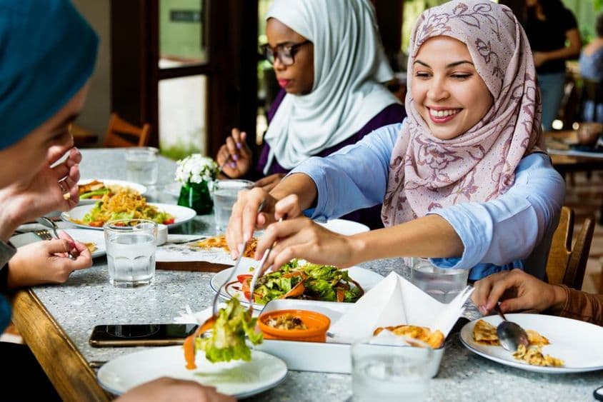 Muslim women dining in hijabs.