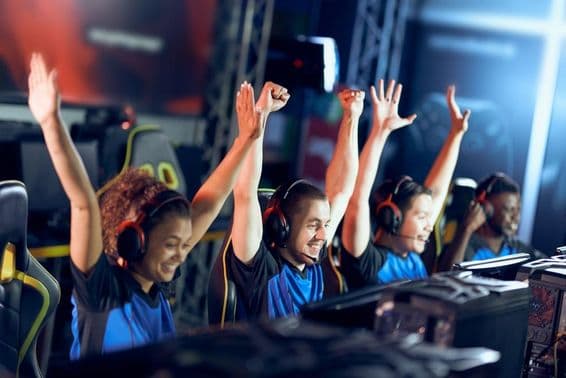 A jubilant team of cyber sport gamers celebrates success during an eSports competition.