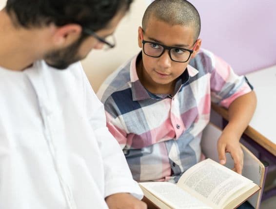 Young Arab teacher studying with a schoolboy.
