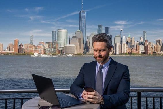 Businessman using a laptop outdoors, working remotely.