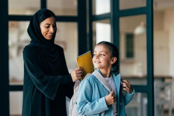Traditional Arab family from Dubai, young girl heading to school in the morning.