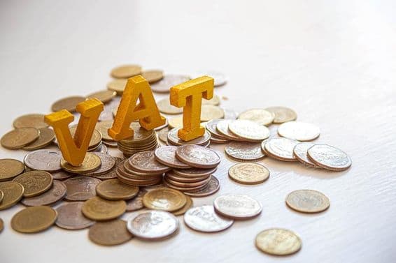 Coins on a table with the letters "Tax" above.