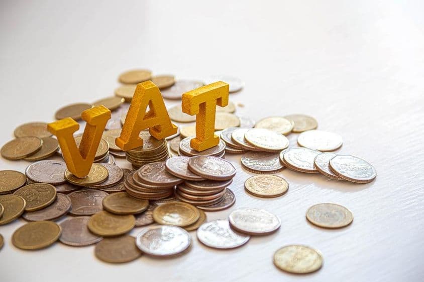 Coins on a table with the letters "Tax" above.