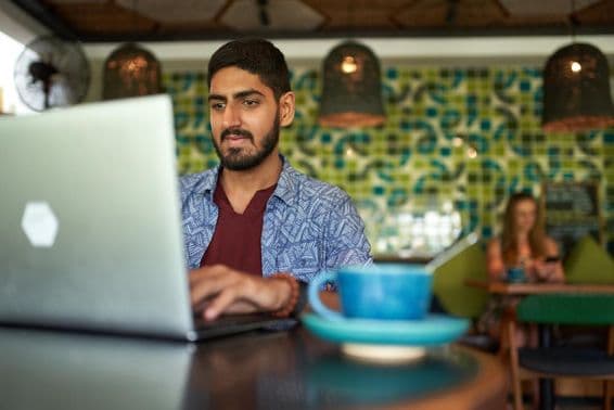 Indian man working in a trendy coworking space.