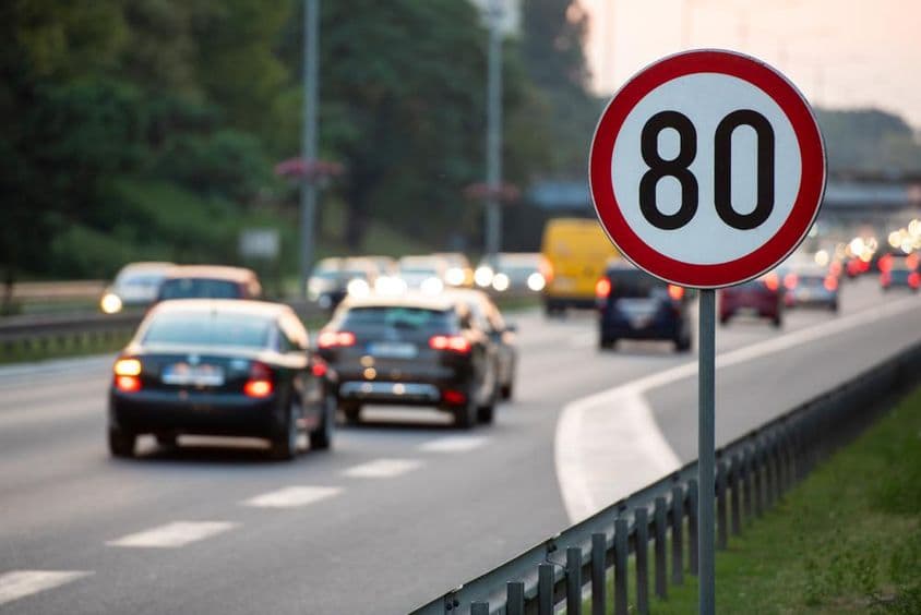 80 km/h speed limit sign on a busy road.