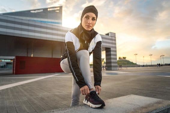 Muslim woman doing city running exercise in downtown.