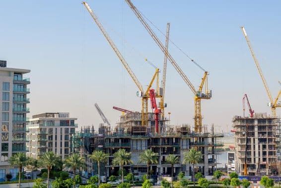 Residential buildings under construction with cranes at the Dubai Creek harbor.