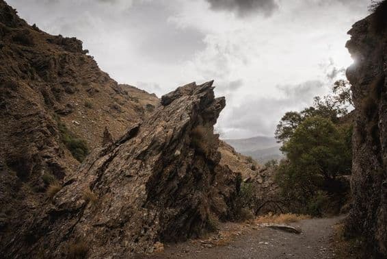 Protruding rock on a mountain path on a cloudy day.