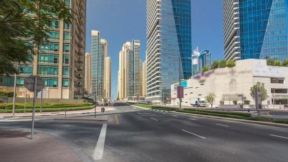 Dubai Marina skyscrapers under sunny blue sky, Dubai, United Arab Emirates.