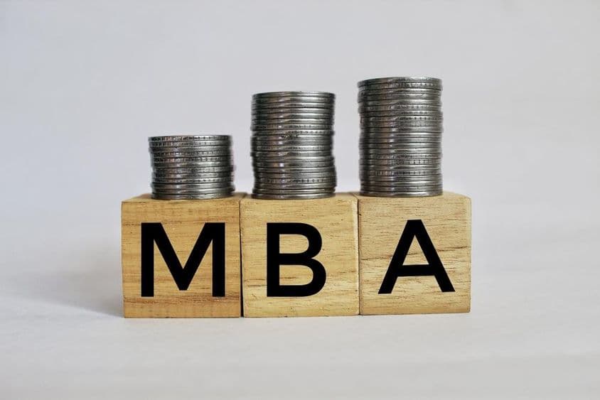 MBA Master of Business Administration written on cubes stacked on coins.