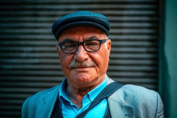 Older man wearing a hat on the street.