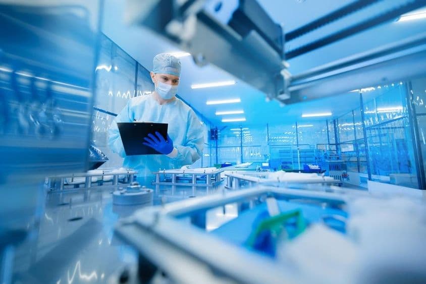 Pharmaceutical worker operating a production line in the pharmaceutical industry.