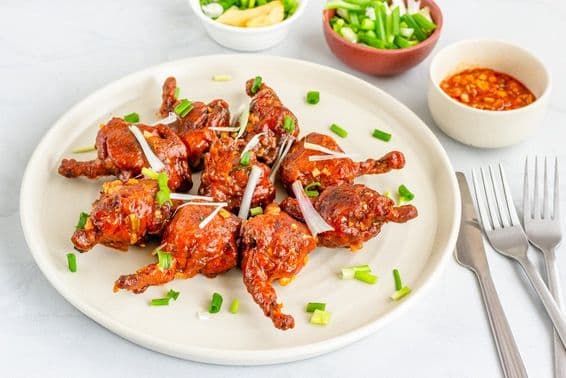 Chicken lollipop, a popular chicken appetizer garnished with shallots.
