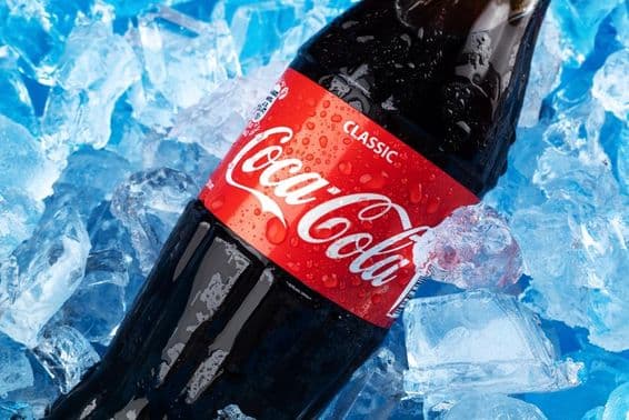 A bottle of Coca-Cola on ice.