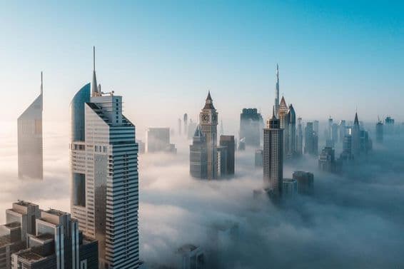 Early morning Dubai's mega-tall skyscrapers swallowed by fog.