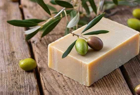 A handmade olive oil soap rests on a wooden table.