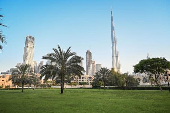 Dubai, United Arab Emirates, green park in residential area with Burj Khalifa in the background.
