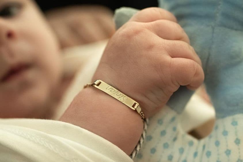 A baby with a gold bracelet.