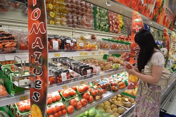 Female shopper selecting fresh fruit at Lulu hypermarket.