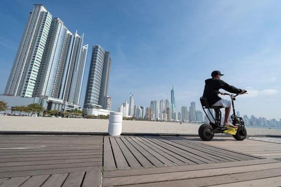 Young man riding a scooter.