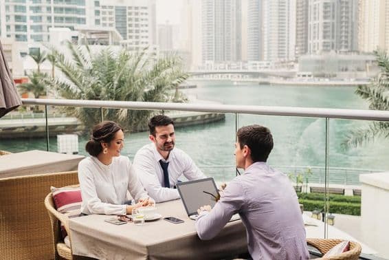 Business meeting on a modern balcony in Dubai Marina.