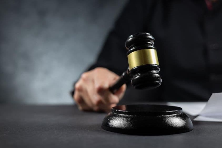 A judge holding a gavel in court.