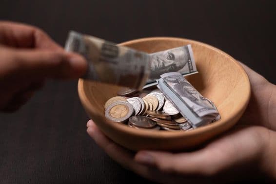 Donation being collected in a wooden vessel.