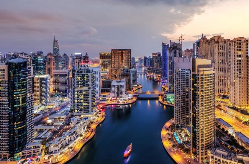 Dubai Marina with illuminated skyscrapers.